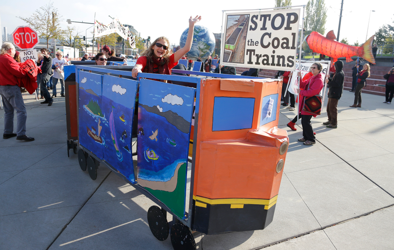 A protester rides in a mock coal train as other protesters demonstrate against trains carrying coal for export moving through Washington state on Thursday, Oct. 17, 2013.AP